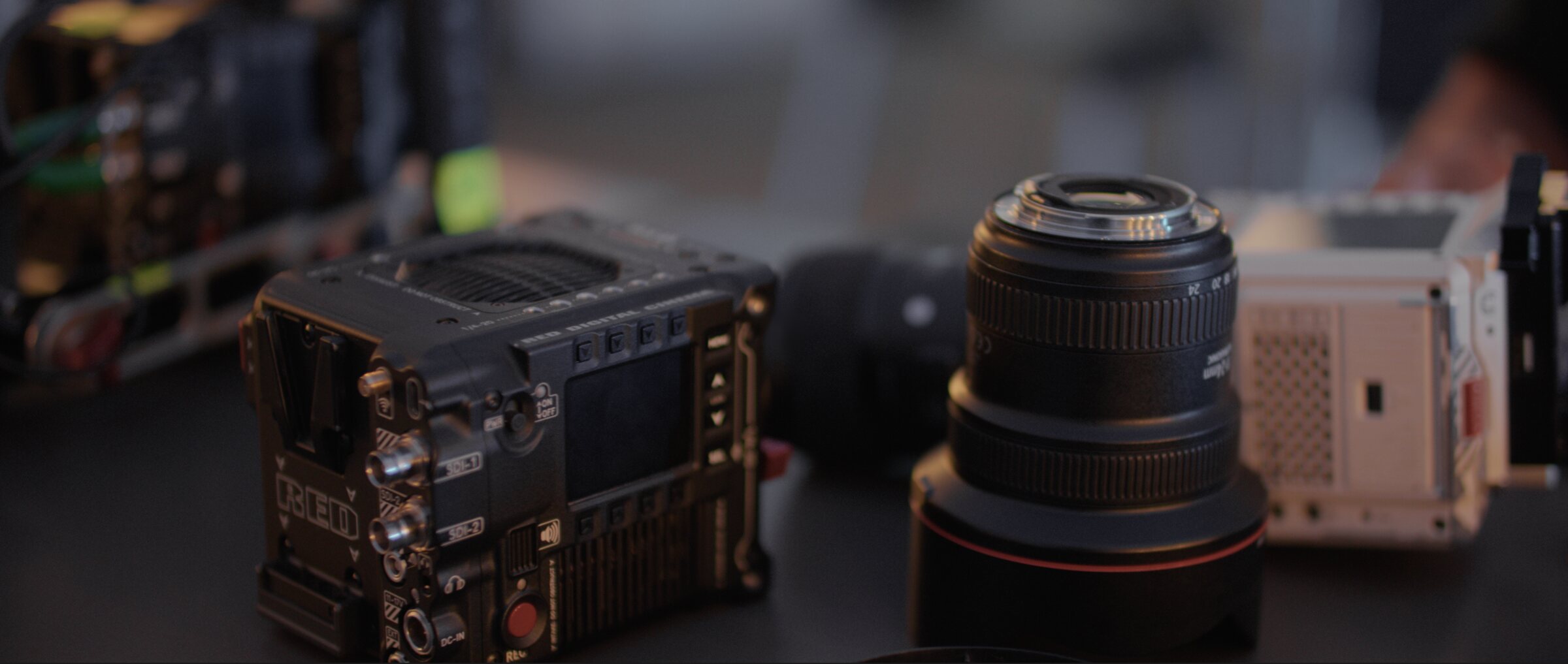 A RED cinema camera body and cine lenses on the bench